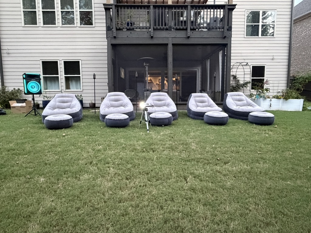 Front view of comfy gray loungers lined up for a backyard movie night