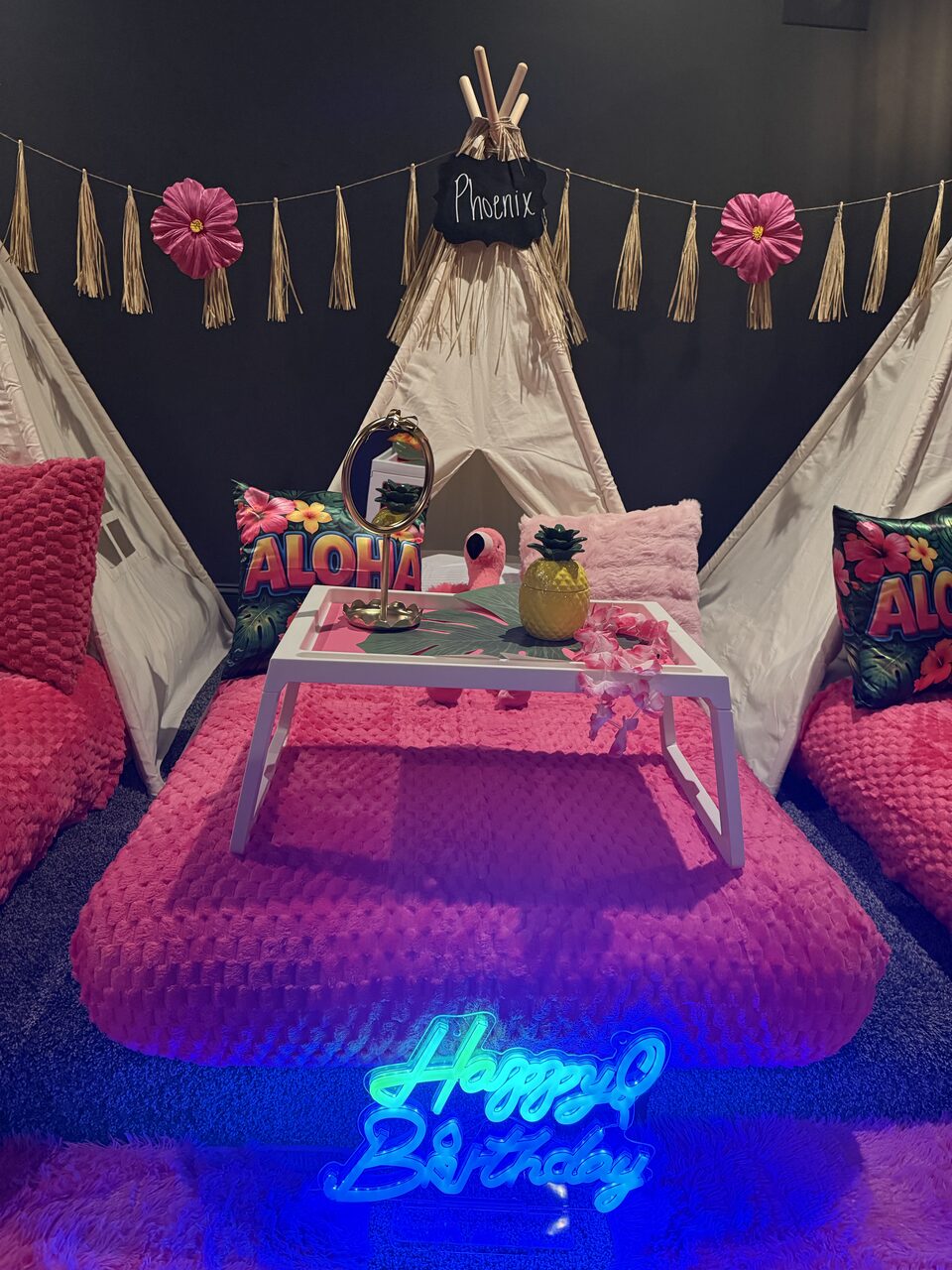 Pink tropical Aloha teepee sleepover with three styled beds and a Happy Birthday neon sign