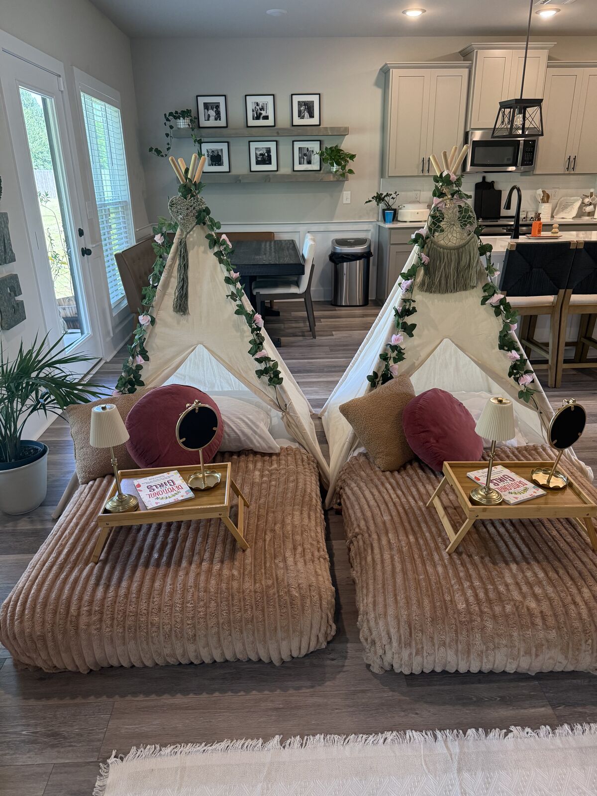 Two blush-and-botanical teepee beds styled side by side