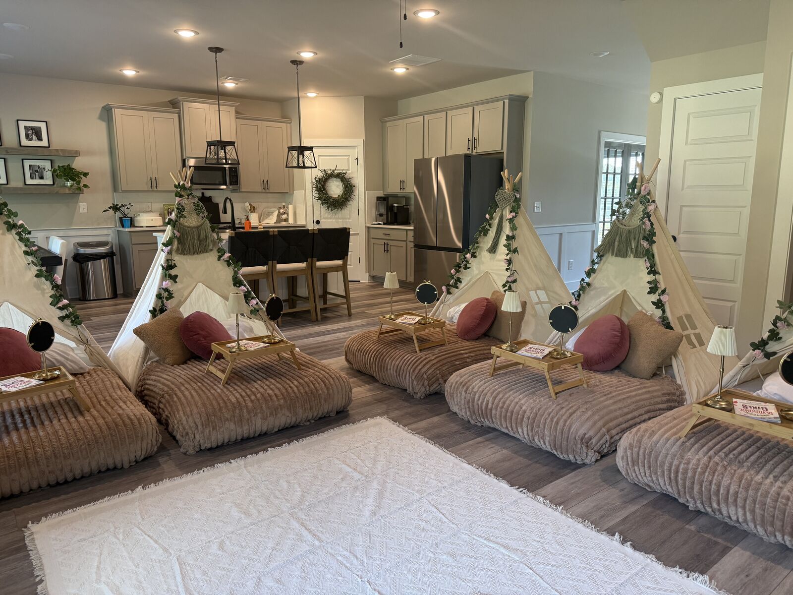 Angled view across a six-teepee blush sleepover setup