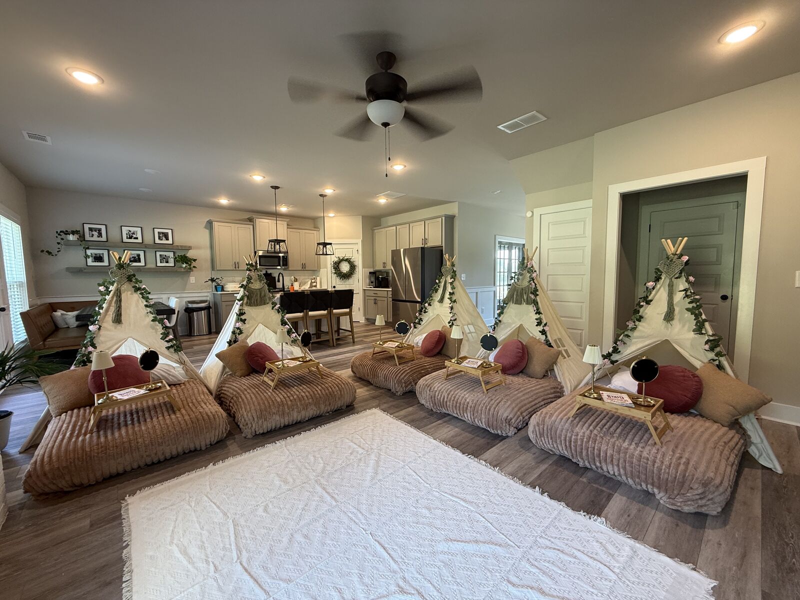 Wide room view of six blush-and-botanical teepees