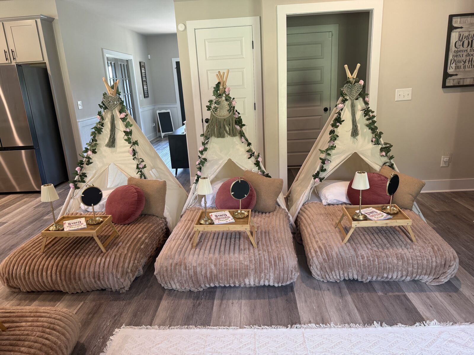 Three blush teepees with botanical garlands and coordinated bedding