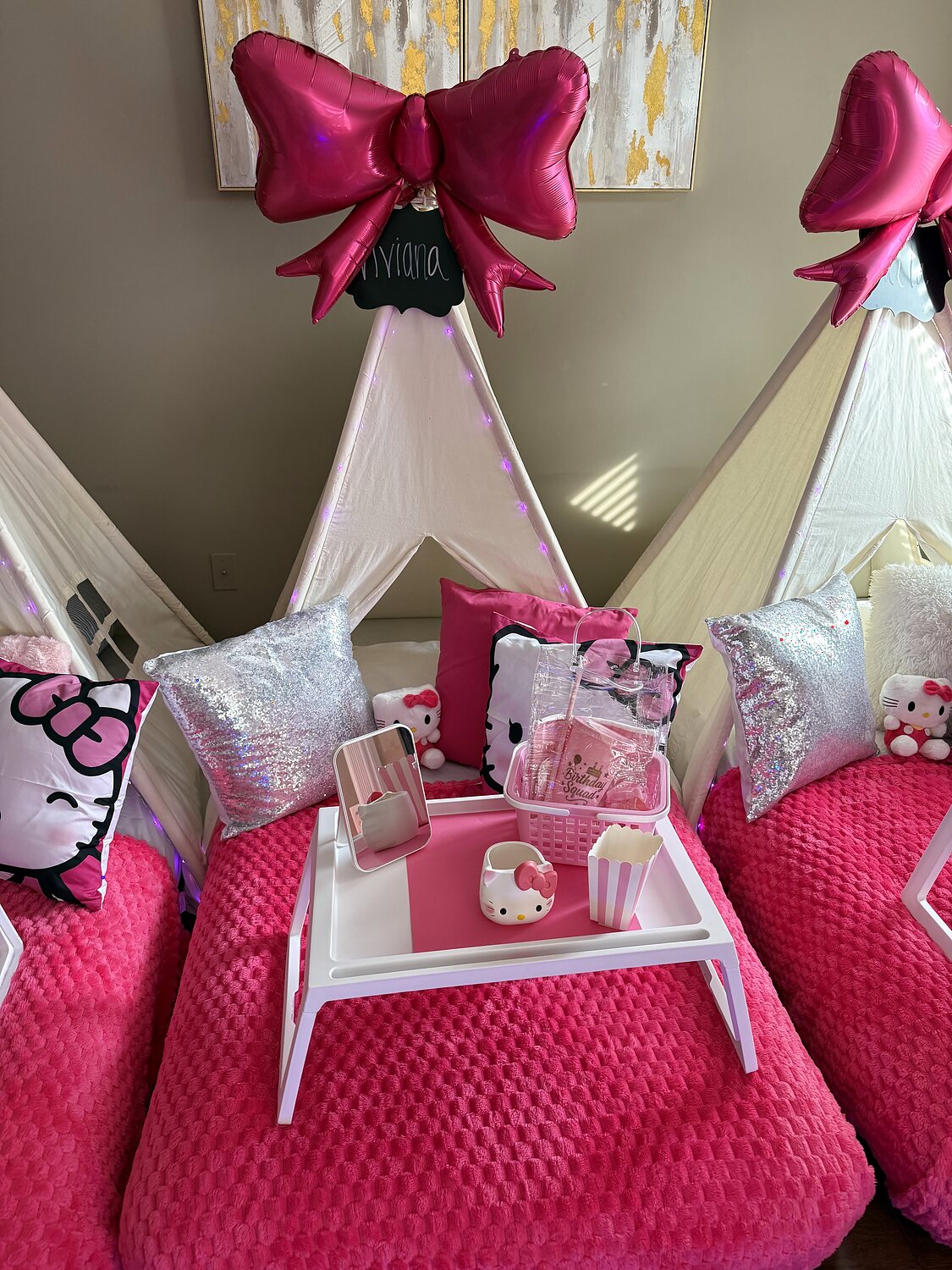 Close-up of a pink bow teepee bed with themed pillow, mirror, mug, and birthday favors