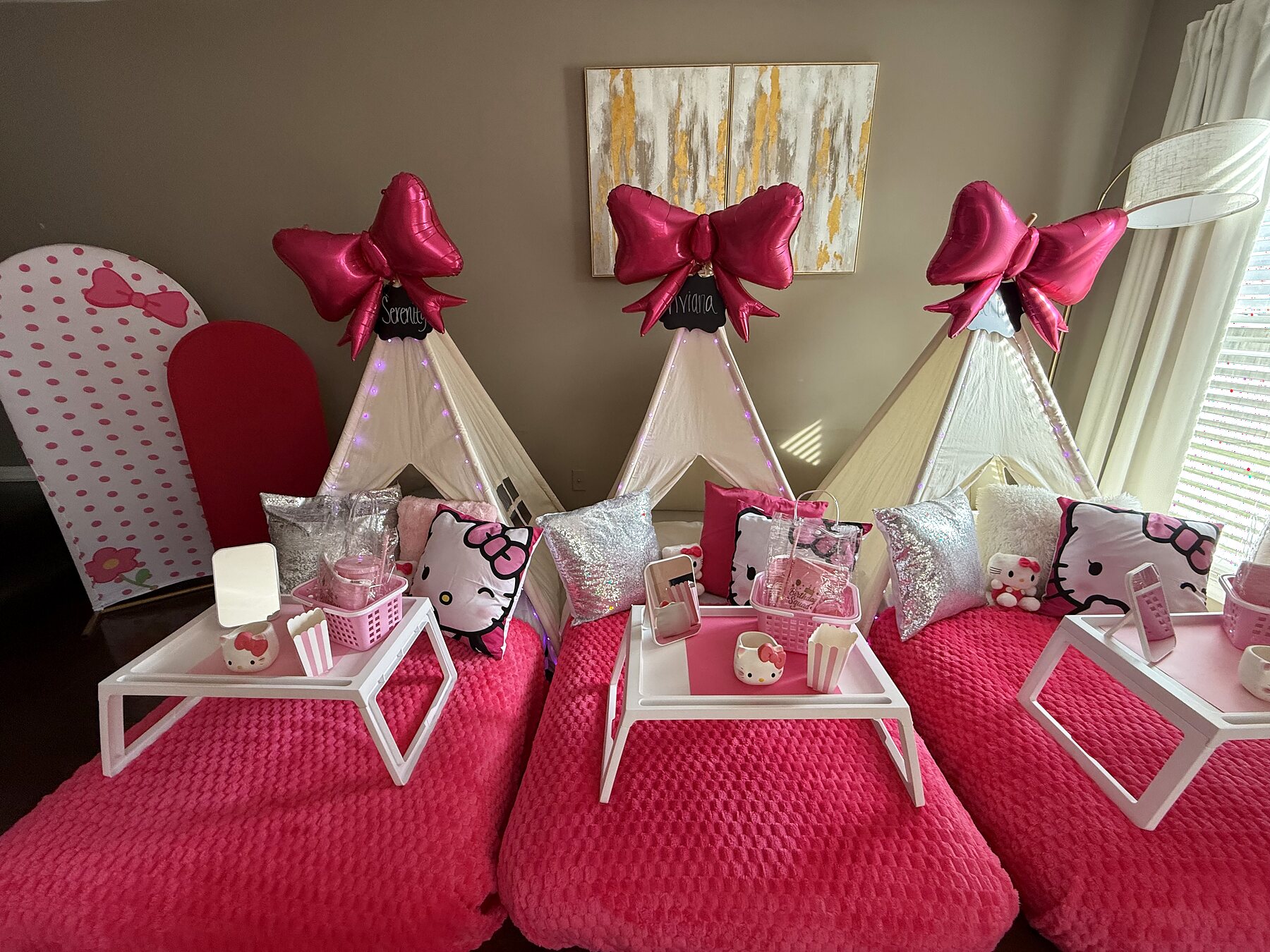 Wide view of three pink Hello Kitty-inspired teepee beds with oversized bow balloons