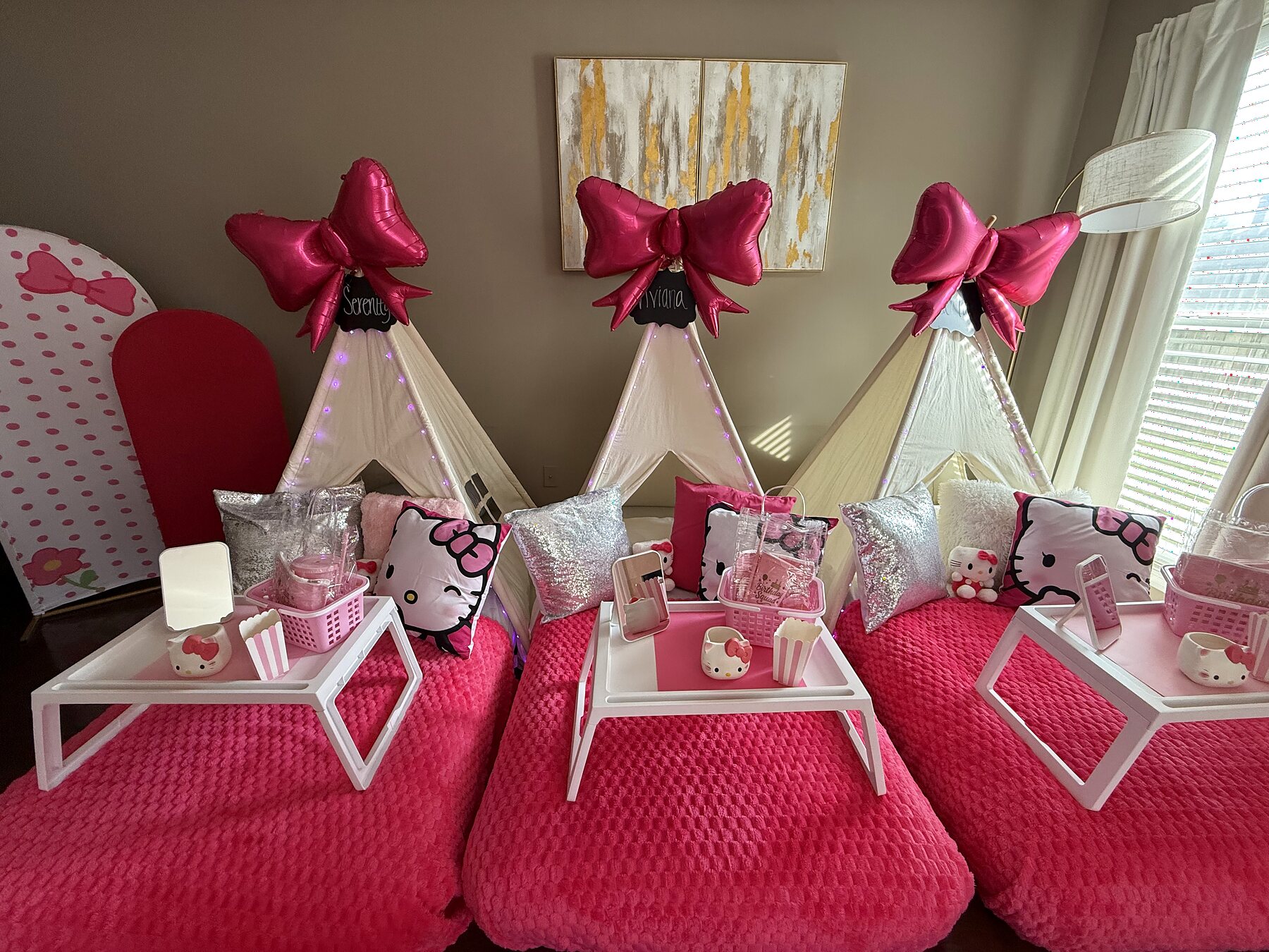 Three vivid pink teepee beds styled with silver pillows, oversized bows, and themed accessories