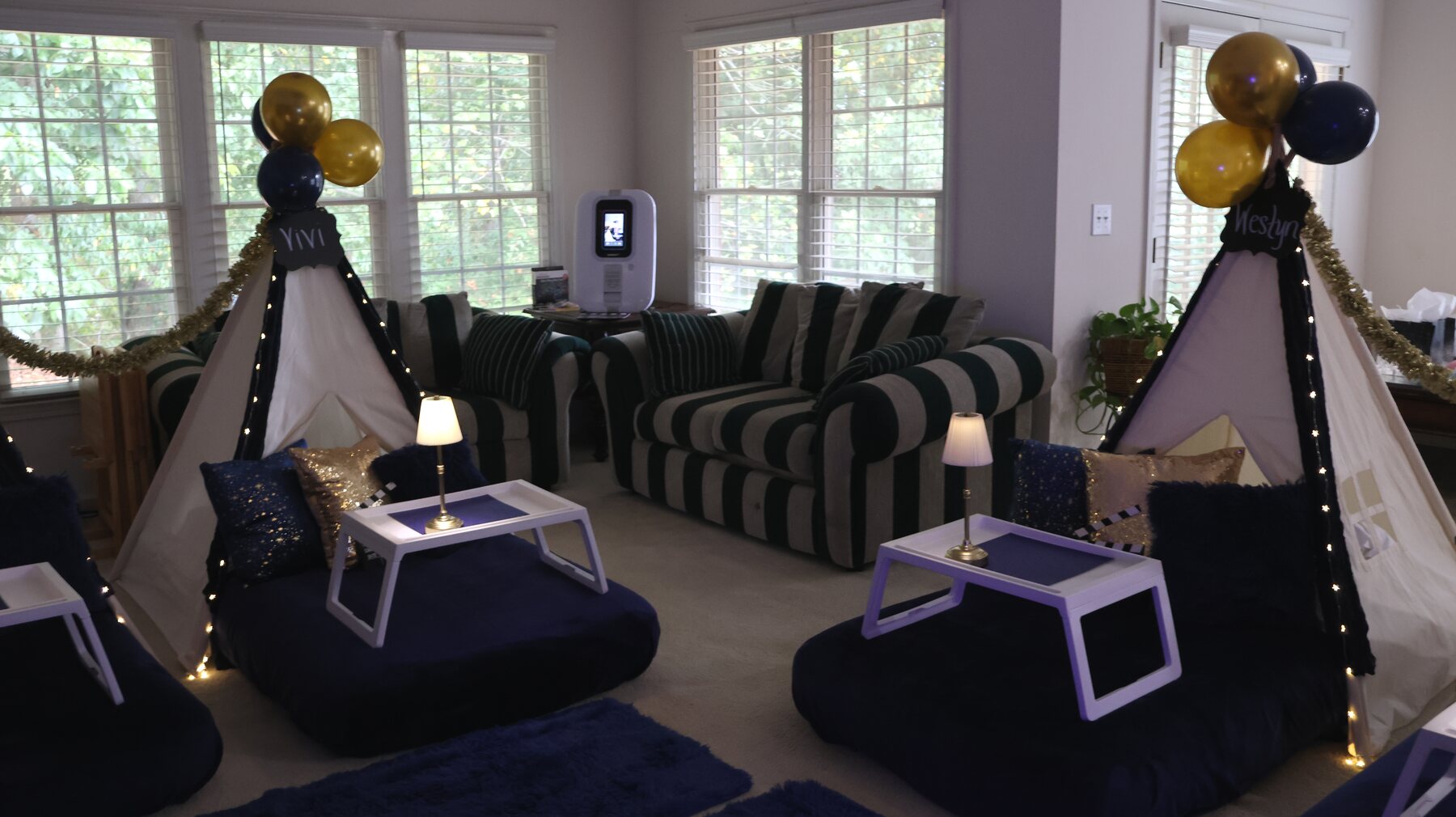Navy-and-gold teepee setup with a tabletop karaoke booth and glowing bedside lamps